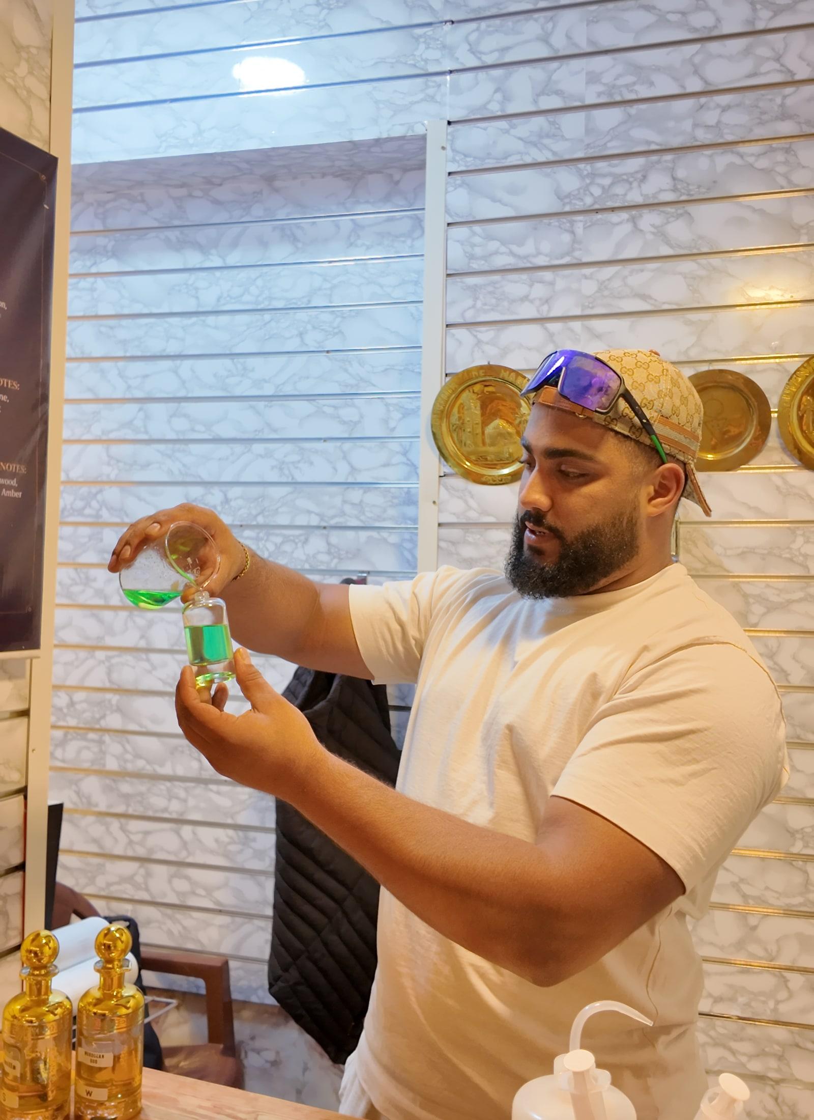 Master perfumer carefully pouring and blending precious oils at The Perfume House